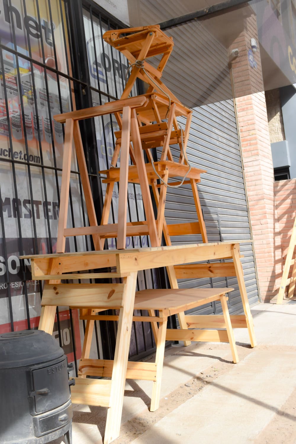 Escaleras de madera y caballetes apilados en la entrada del corralón
